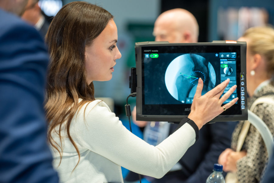 An industry representative demonstrates their product to delegates at an ISHA Annual Scientific Meeting