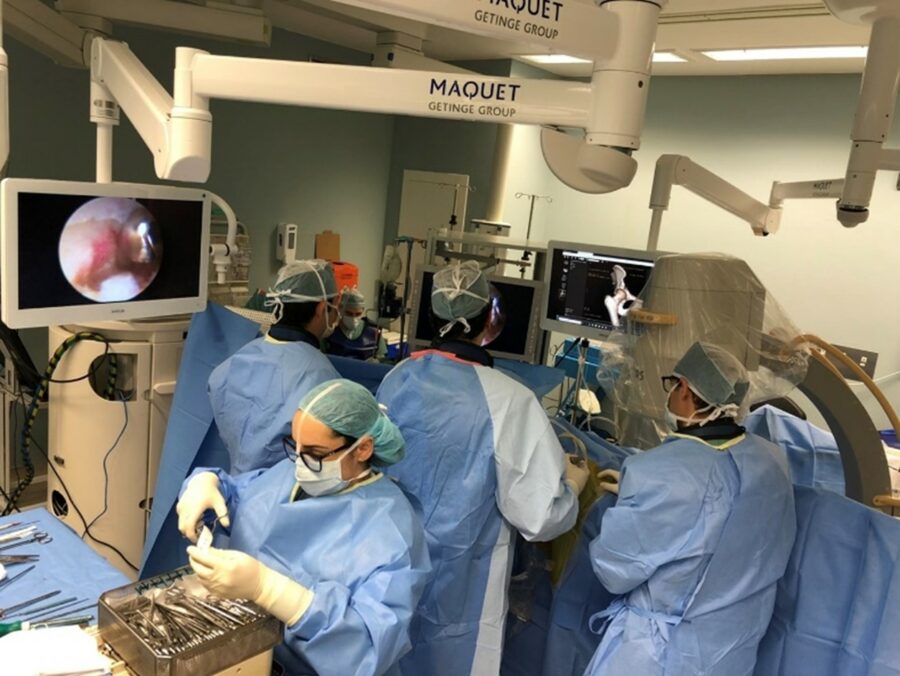 Image of an operating theatre taken during a hip arthroscopy showing monitor screen and X-ray imaging taking place